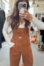 Load image into Gallery viewer, Person wearing brown overalls taking a mirror selfie in a store.
