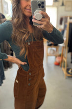 Load image into Gallery viewer, Person wearing brown overalls taking a mirror selfie in a store.
