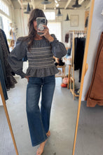 Load image into Gallery viewer, Person wearing a patterned sweater and jeans in a clothing store.