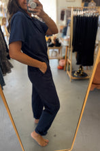 Load image into Gallery viewer, Person wearing navy blue pajama set standing in front of a mirror in a store.