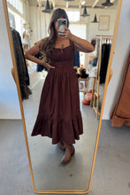 Load image into Gallery viewer, Person wearing a brown dress standing in front of a mirror in a store.
