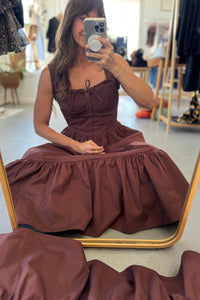 Woman wearing a brown dress in a store setting