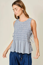 Load image into Gallery viewer, Woman wearing a sleeveless checkered top with ruffle details on a beige background