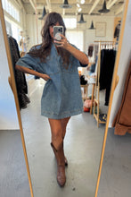 Load image into Gallery viewer, Person wearing a denim dress and brown boots in a clothing store.