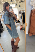 Load image into Gallery viewer, Person wearing a denim dress and brown boots in a clothing store.