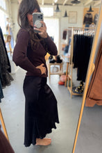 Load image into Gallery viewer, Person wearing a brown ribbed sweater and black skirt in a clothing store.