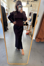Load image into Gallery viewer, Person taking a mirror selfie wearing a dark outfit in a clothing store.