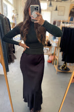Load image into Gallery viewer, Person wearing a black top and dark skirt in a clothing store.