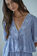 Load image into Gallery viewer, Woman wearing a blue embroidered dress against a neutral background
