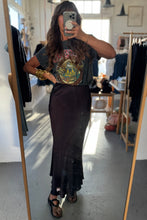 Load image into Gallery viewer, Person taking a mirror selfie wearing a graphic t-shirt and black skirt in a clothing store.