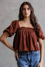 Load image into Gallery viewer, Woman wearing a brown top with puffed sleeves and blue jeans against a gray background
