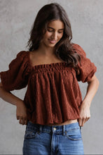 Load image into Gallery viewer, Woman wearing a brown textured top and blue jeans against a gray background