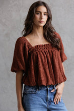 Load image into Gallery viewer, Woman wearing a brown textured top and blue jeans against a gray background