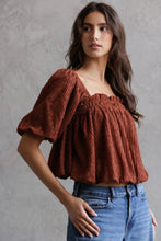 Load image into Gallery viewer, Woman wearing a brown textured top and blue jeans against a gray background