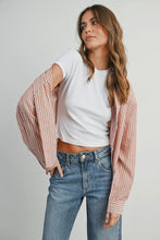 Load image into Gallery viewer, Woman wearing a white t-shirt and blue jeans with a striped pink and white shirt over her shoulders against a plain background.
