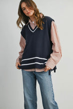 Load image into Gallery viewer, Woman wearing a navy sweater vest over a striped shirt with blue jeans on a plain background