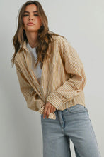 Load image into Gallery viewer, Woman wearing a beige striped shirt and blue jeans against a plain background