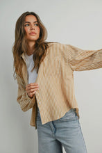 Load image into Gallery viewer, Woman wearing a beige striped shirt and light blue jeans against a plain background