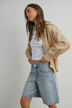 Load image into Gallery viewer, Woman wearing a beige striped shirt, white top, and denim shorts on a plain background