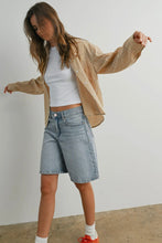 Load image into Gallery viewer, Woman wearing a beige cardigan, white top, denim shorts, and red shoes against a plain background