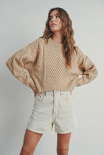Load image into Gallery viewer, Woman wearing a beige cable knit sweater and light-colored shorts against a plain background