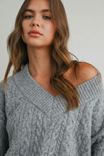 Load image into Gallery viewer, Woman wearing a gray cable knit sweater against a plain background