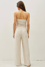 Load image into Gallery viewer, Woman wearing a strapless beige jumpsuit on a white background