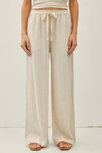 Load image into Gallery viewer, Person wearing beige wide-leg pants with a white background
