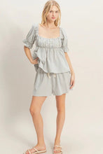 Load image into Gallery viewer, Woman wearing a light gray dress with puff sleeves on a plain background