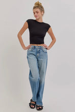 Load image into Gallery viewer, Woman wearing a black top and blue jeans on a plain background