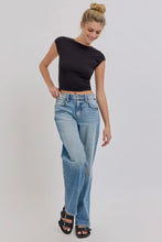 Load image into Gallery viewer, Woman wearing a black crop top and light blue jeans on a plain background