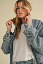 Load image into Gallery viewer, Woman wearing a denim jacket over a white shirt on a beige background