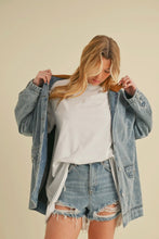 Load image into Gallery viewer, Woman wearing a denim jacket, white sweatshirt, and ripped denim shorts on a beige background