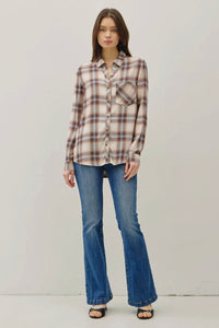 Woman wearing a plaid shirt and blue jeans on a plain background