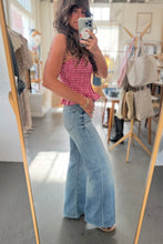 Load image into Gallery viewer, Woman taking a mirror selfie wearing a red checkered top and blue jeans in a store.