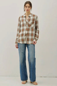 Person wearing a plaid shirt and jeans on a plain background