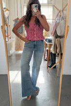 Load image into Gallery viewer, Woman taking a mirror selfie wearing a red checkered top and blue jeans in a store.