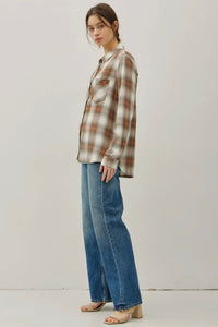 Person wearing a plaid shirt and jeans on a plain background