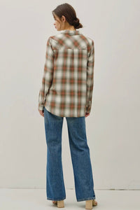 Person wearing a plaid shirt and jeans on a plain background