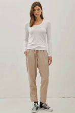 Load image into Gallery viewer, Woman wearing a white long-sleeve top and beige pants against a plain background