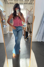 Load image into Gallery viewer, Person taking a mirror selfie wearing a red checkered top and blue jeans in a clothing store.