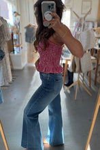 Load image into Gallery viewer, Woman taking a mirror selfie wearing a red checkered top and blue jeans in a clothing store.