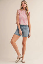 Load image into Gallery viewer, Woman wearing a pink ruffled top and denim shorts on a beige background