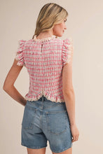 Load image into Gallery viewer, Woman wearing a pink checkered top with ruffled sleeves and denim shorts on a beige background