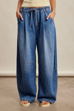 Load image into Gallery viewer, Person wearing blue wide-leg jeans on a neutral background
