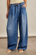 Load image into Gallery viewer, Person wearing wide-leg blue jeans on a neutral background