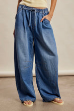 Load image into Gallery viewer, Person wearing blue wide-leg jeans on a neutral background