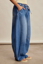 Load image into Gallery viewer, Person wearing blue denim pants on a neutral background