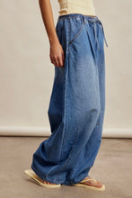 Load image into Gallery viewer, Person wearing wide-leg blue jeans on a neutral background