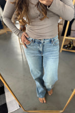 Load image into Gallery viewer, Person wearing a beige top and blue jeans standing in front of a mirror.